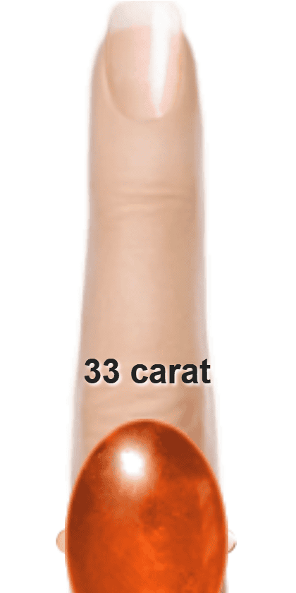 Orangey Red 33 carat cabochon-cut Sunstone on a ring and finger.
